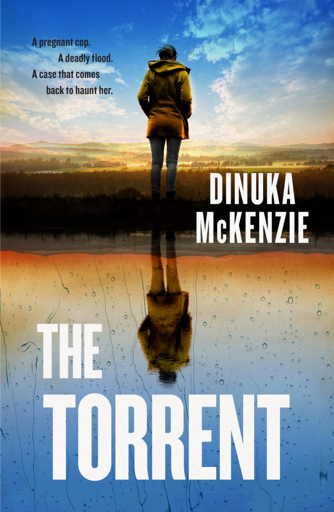 Book Cover of The Torrent by Dinuka McKenzie showing the back of a woman staring out into the country side. The bottom half of the image shows her reflection in water. The blurb reads: a pregnant cop, a deadly flood. A case that comes back to haunt her.