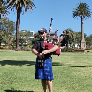Dave from Anna's Shop Around the Corner playing bagpipes in the park opposite